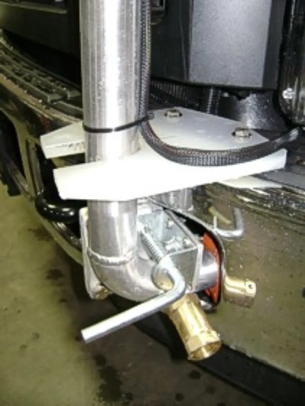 Exterior view of small fire truck showing cab, body compartments, and wheel/tire area.