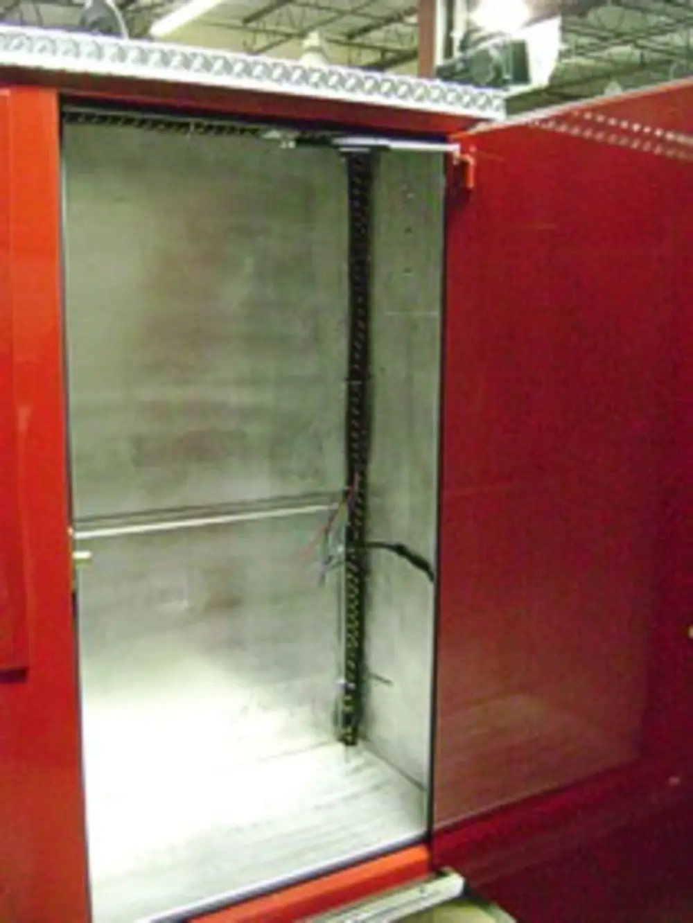 Exterior view of small fire truck showing cab, body compartments, and wheel/tire area.