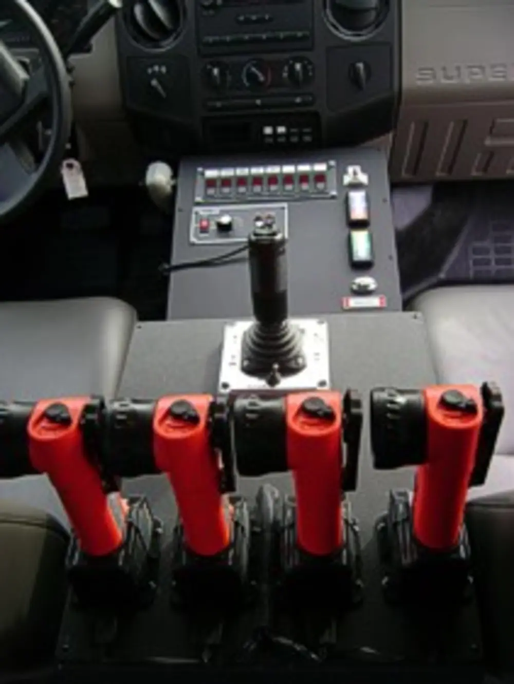 Exterior view of small fire truck showing cab, body compartments, and wheel/tire area.