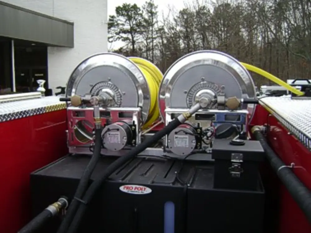 Exterior view of small fire truck showing cab, body compartments, and wheel/tire area.
