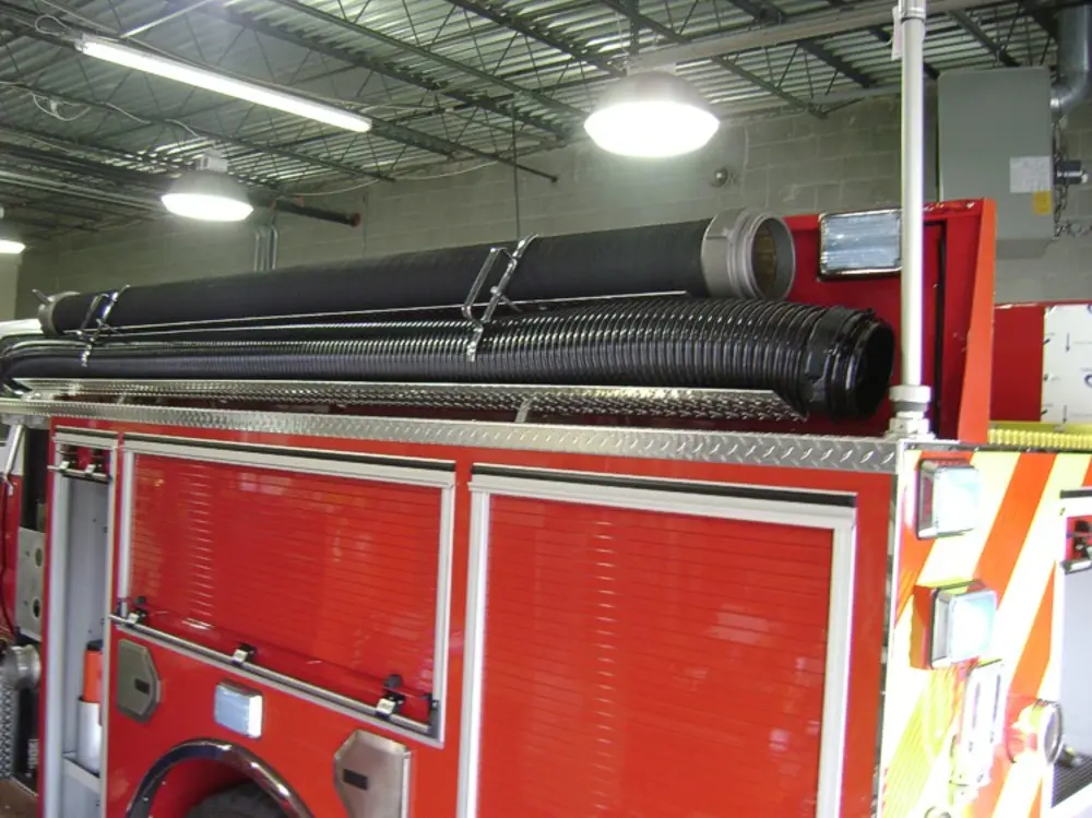 Exterior view of small fire truck showing cab, body compartments, and wheel/tire area.