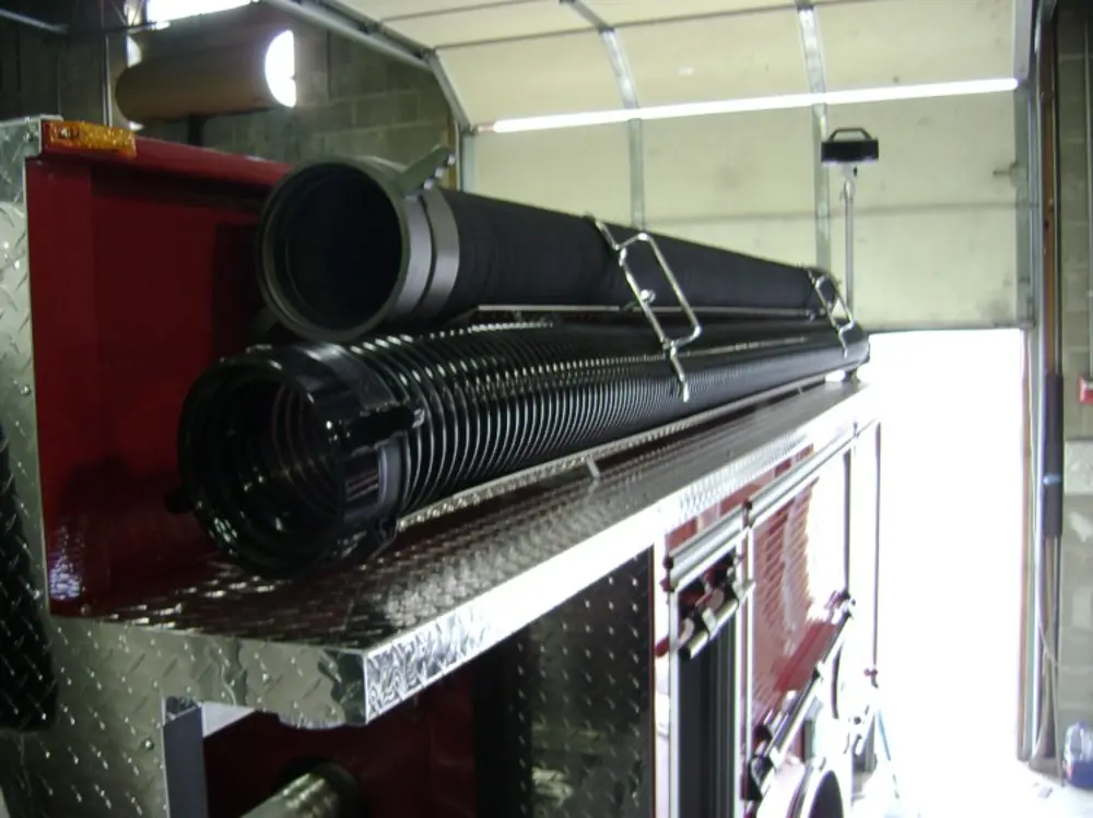 Exterior view of small fire truck showing cab, body compartments, and wheel/tire area.