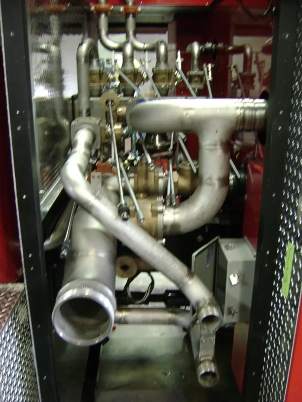 Exterior view of small fire truck showing cab, body compartments, and wheel/tire area.