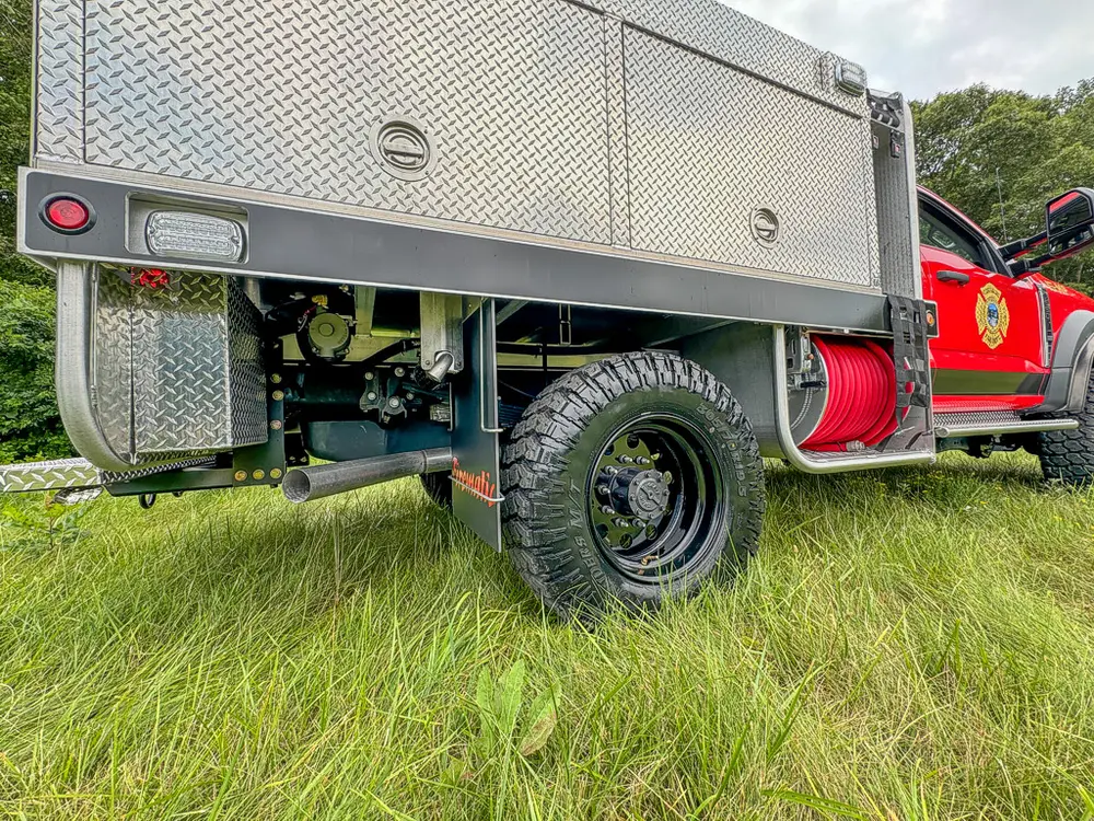 Rear-right side view showing tandem body section, rear wheel, and hose reel.