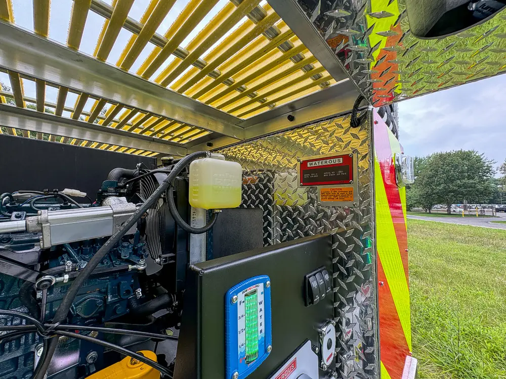 Upper rear pump bay view with hydraulic components under raised door.