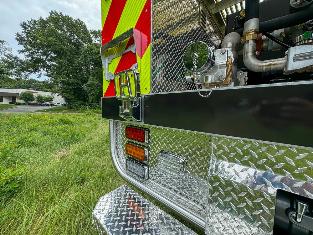 Right rear corner close-up with taillight and open pump compartment edge.