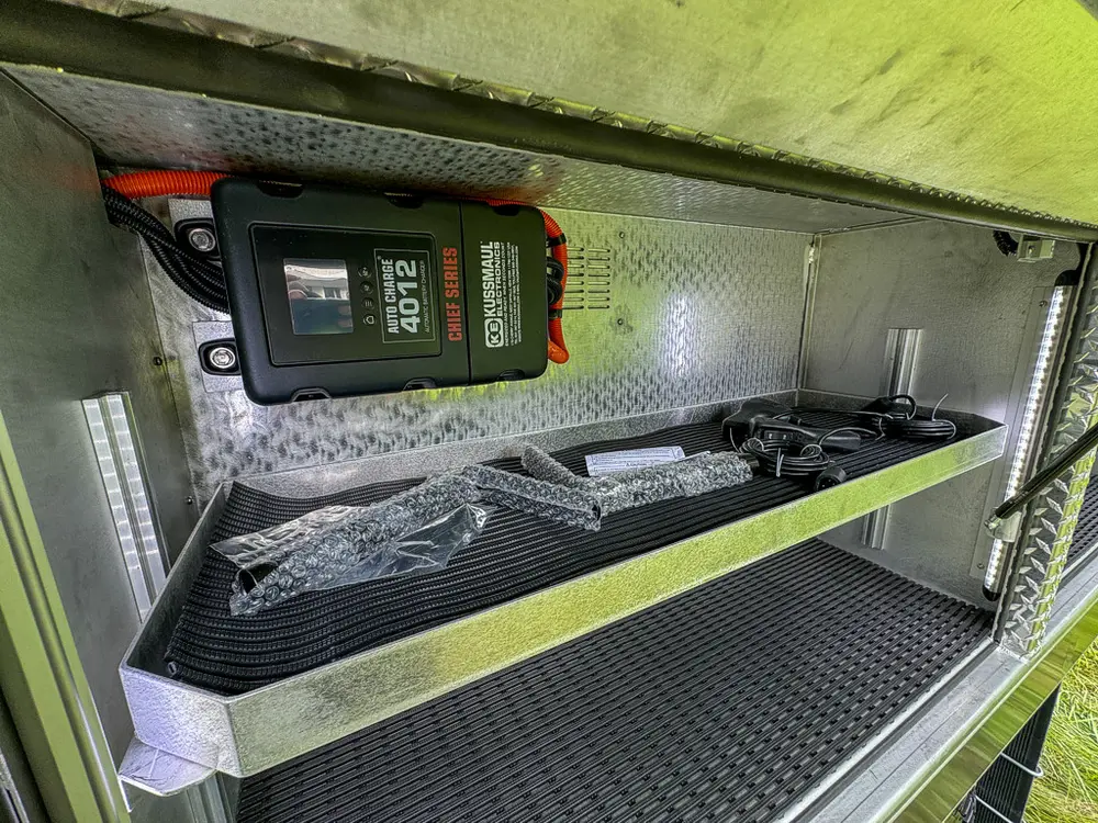 Open side compartment with mounted charger and loose accessories.