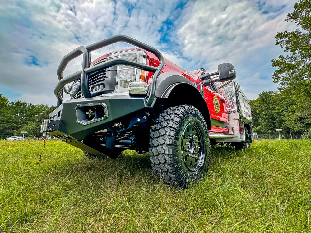 Low front-left exterior angle showing grille guard and off-road tire.