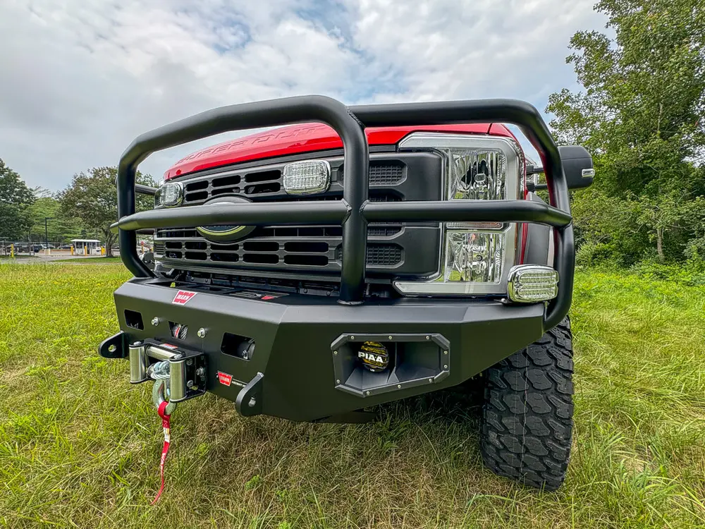 Head-on front close-up with grille, brush guard, and bumper winch.