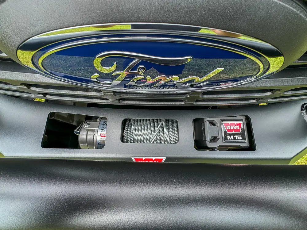 Grille and winch close-up centered on Ford emblem.