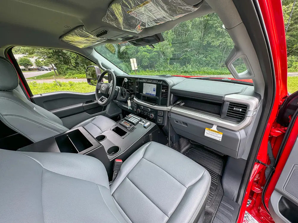 Front cabin interior view from driver side with console and dashboard.