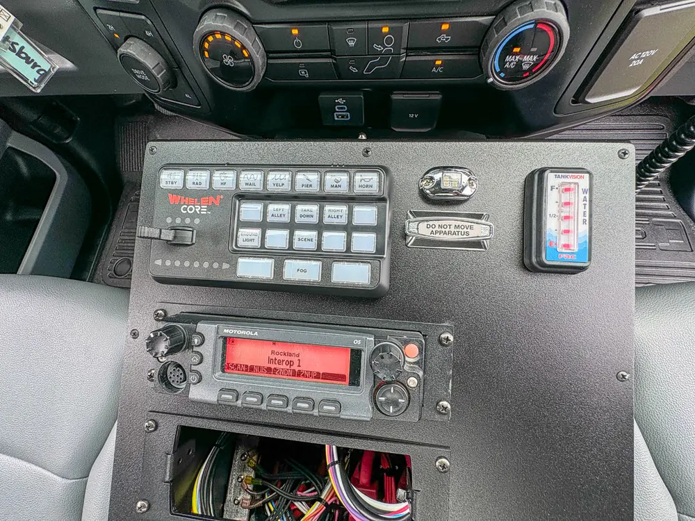 Center control panel close-up with radio, keypad, and emergency switches.