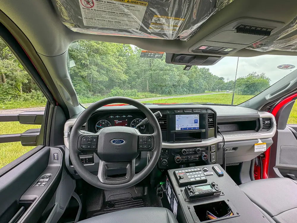 Driver cockpit view showing steering wheel and center console controls.