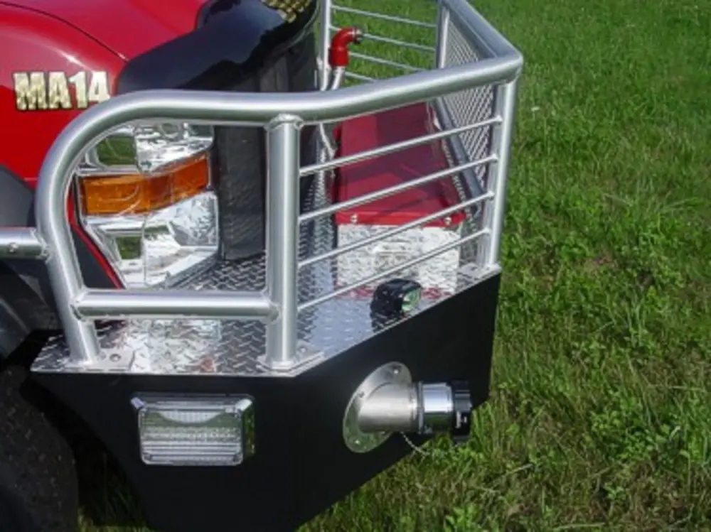 Exterior view of small fire truck showing cab, body compartments, and wheel/tire area.