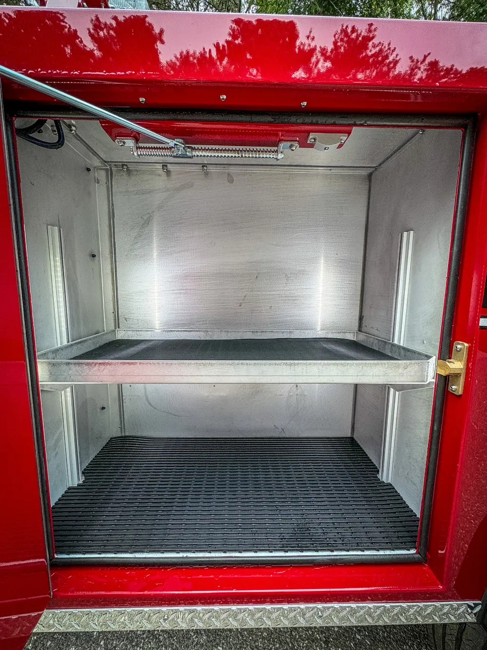 Compartment interior close-up with shelf and ribbed floor mat.