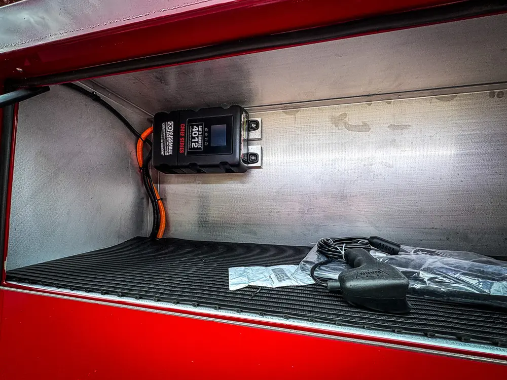 Top-side compartment interior with mounted charger and small bag.