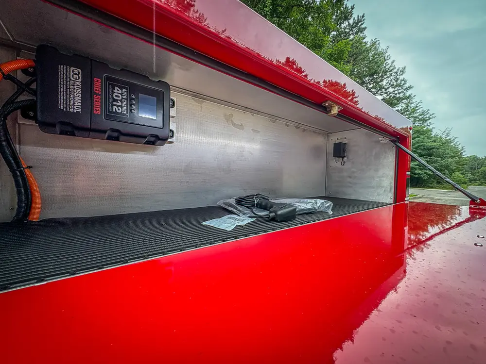 Top-side compartment close-up with mounted charger and cable routing.