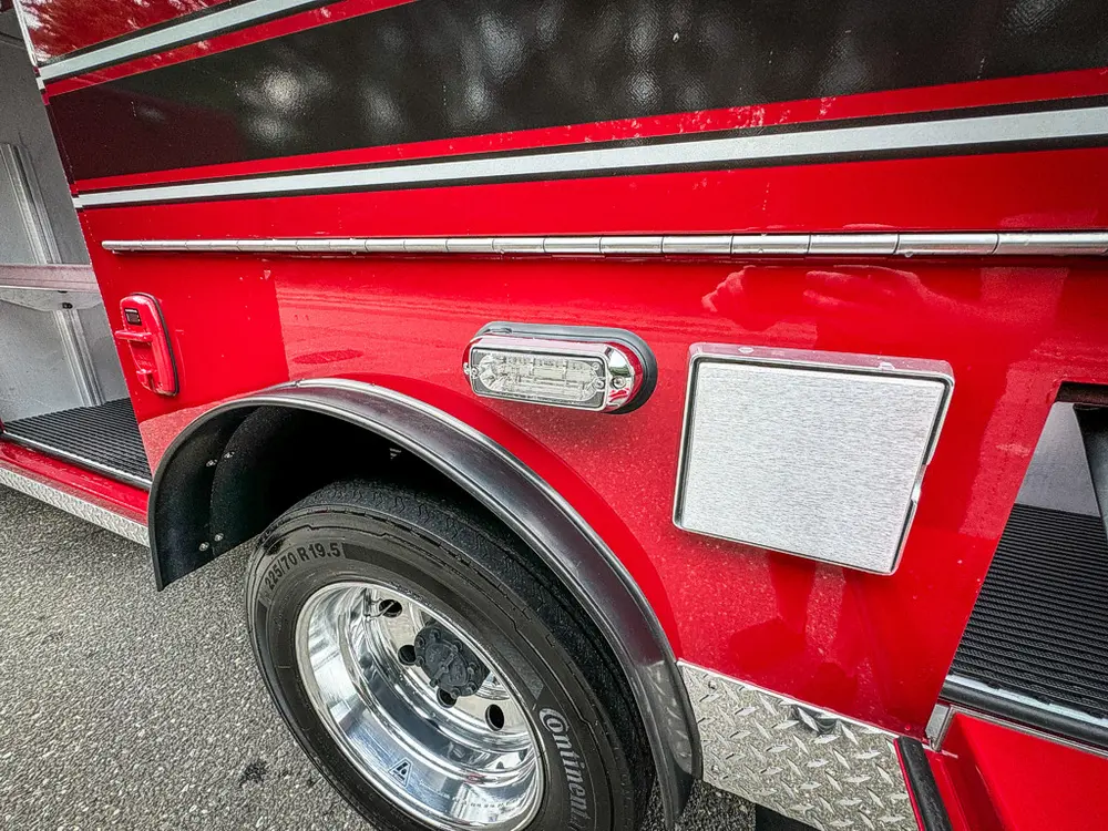 Lower side body close-up with wheel and compartment latch.