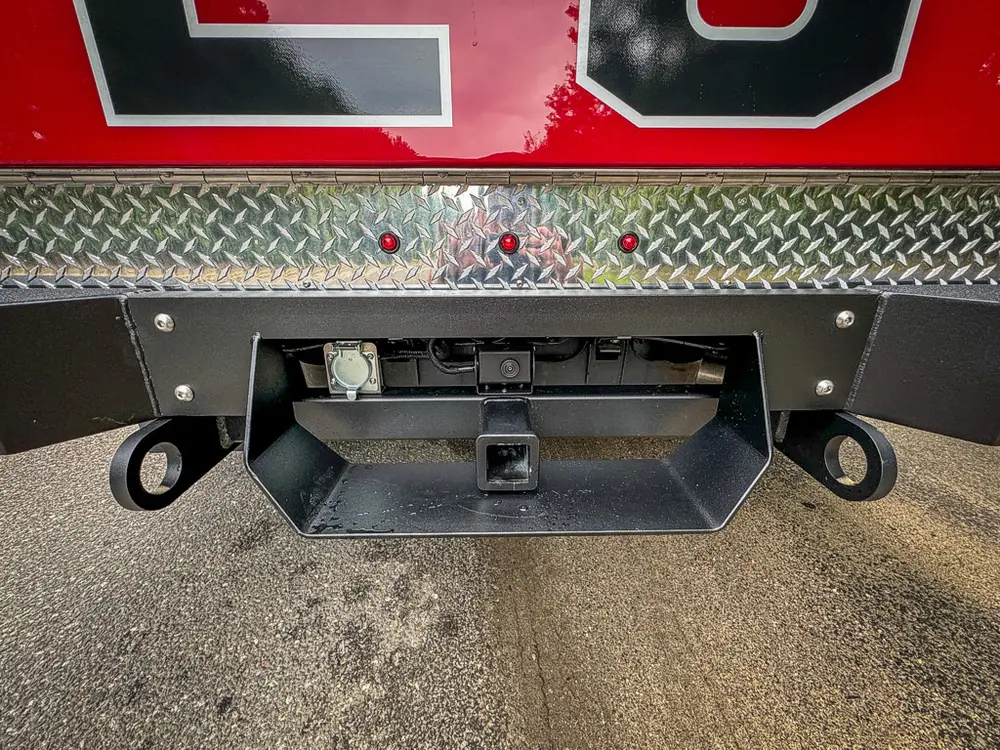 Rear center close-up of hitch receiver and tow points under bumper.