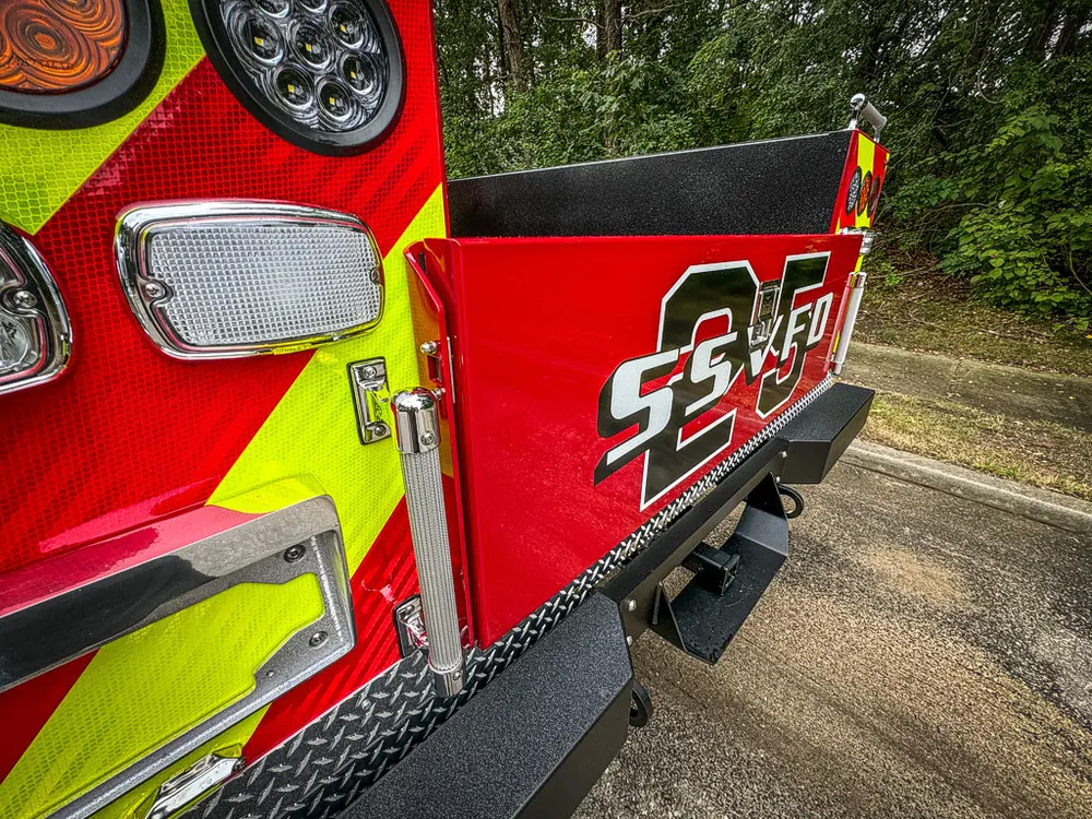 Rear-right corner close-up with taillight stack and rear step edge.