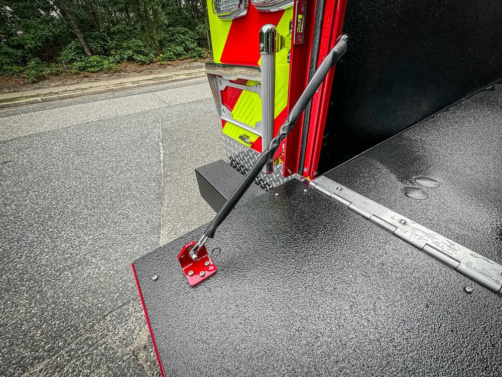Tailgate hinge and support bracket close-up at right corner.