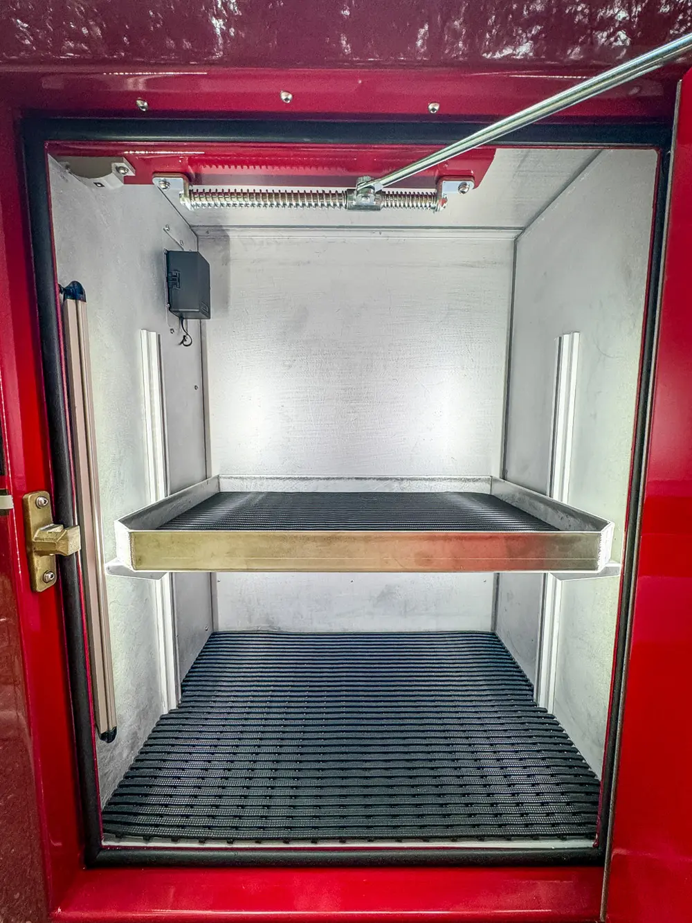 Open side compartment close-up with shelf and empty lower bay.