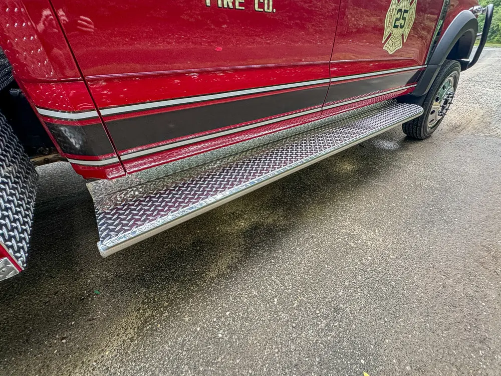 Lower cab side step and trim close-up along passenger door.