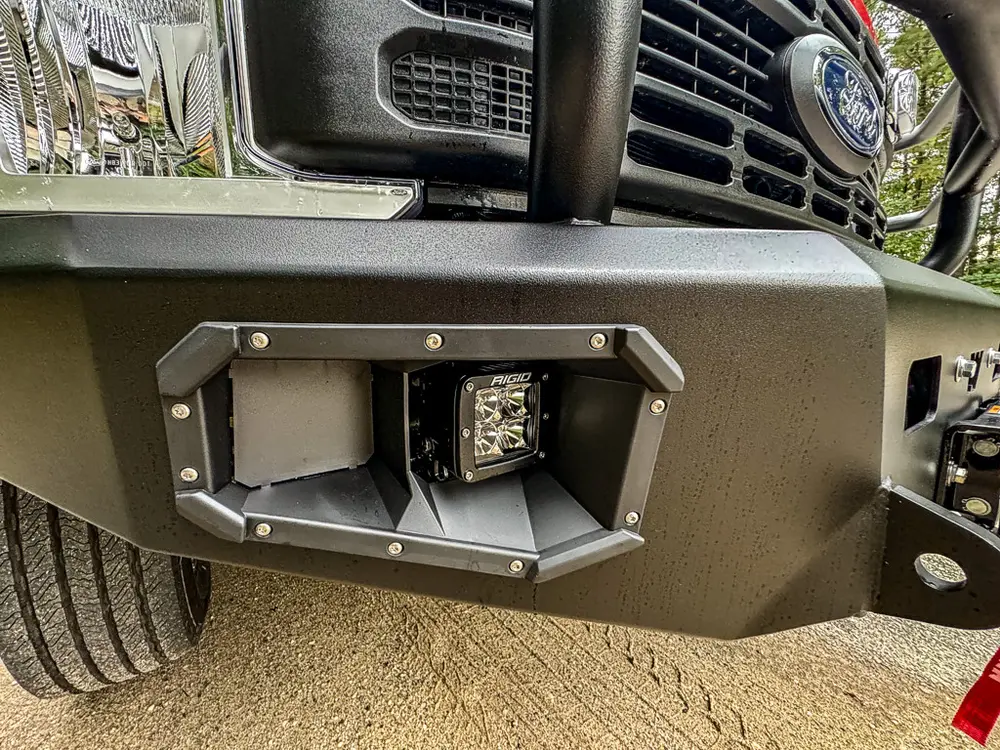 Front bumper corner close-up with square auxiliary light pod.