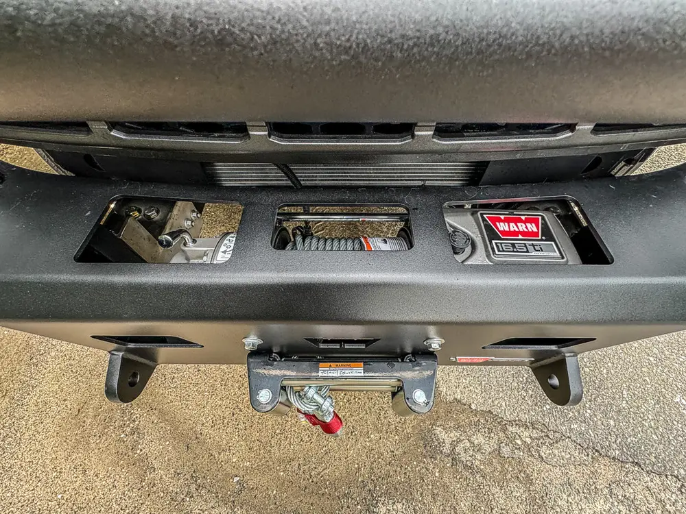 Lower front bumper close-up with winch fairlead and tow hooks.