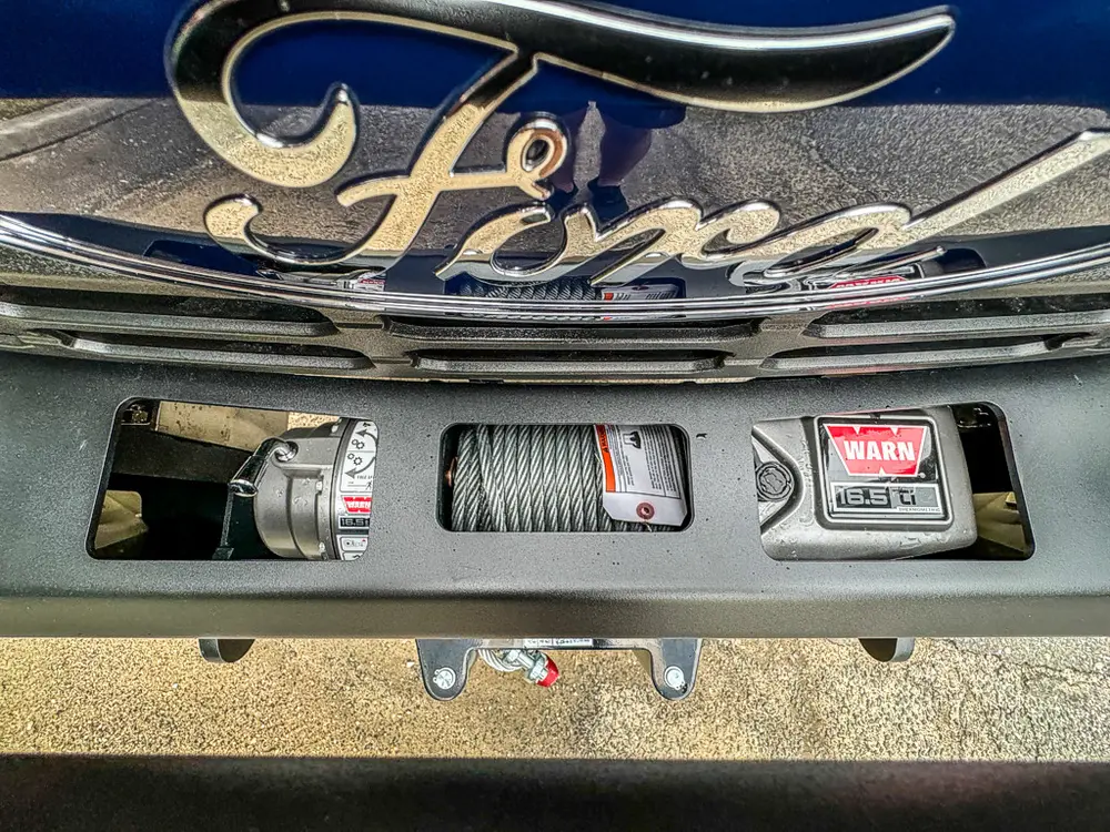 Front grille and bumper close-up with winch and license area.