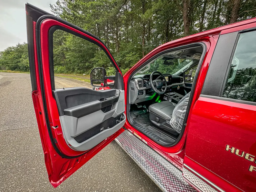 Open front driver door view showing steering area and seat.