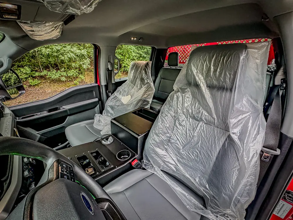 Wide interior view across front seats and dashboard controls.