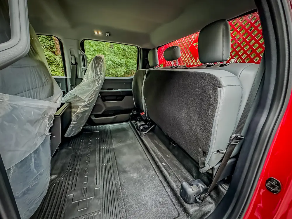 Rear cabin view from opposite door showing bench and mesh panel.