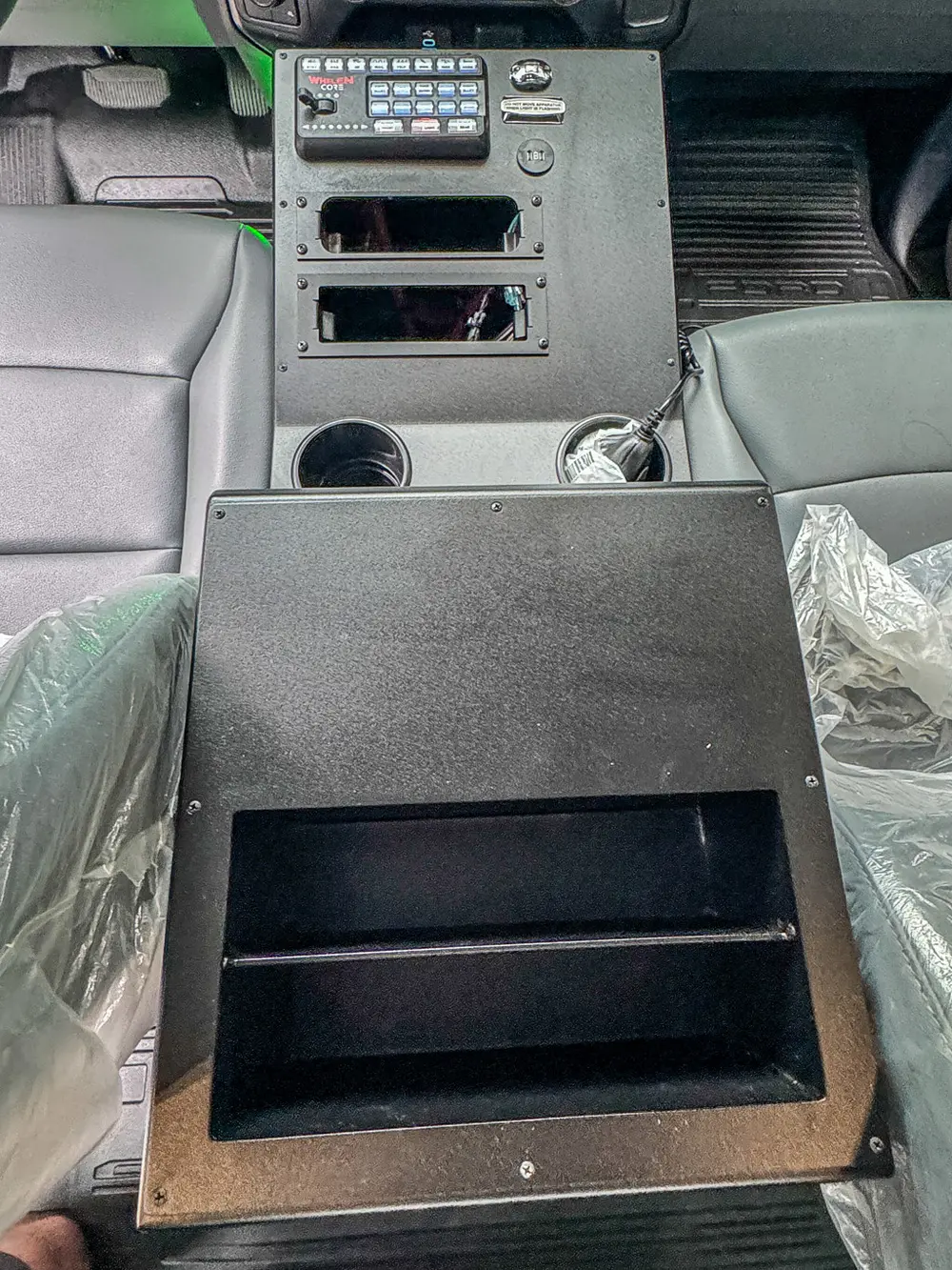 Rear center console fold-down panel close-up between front seats.