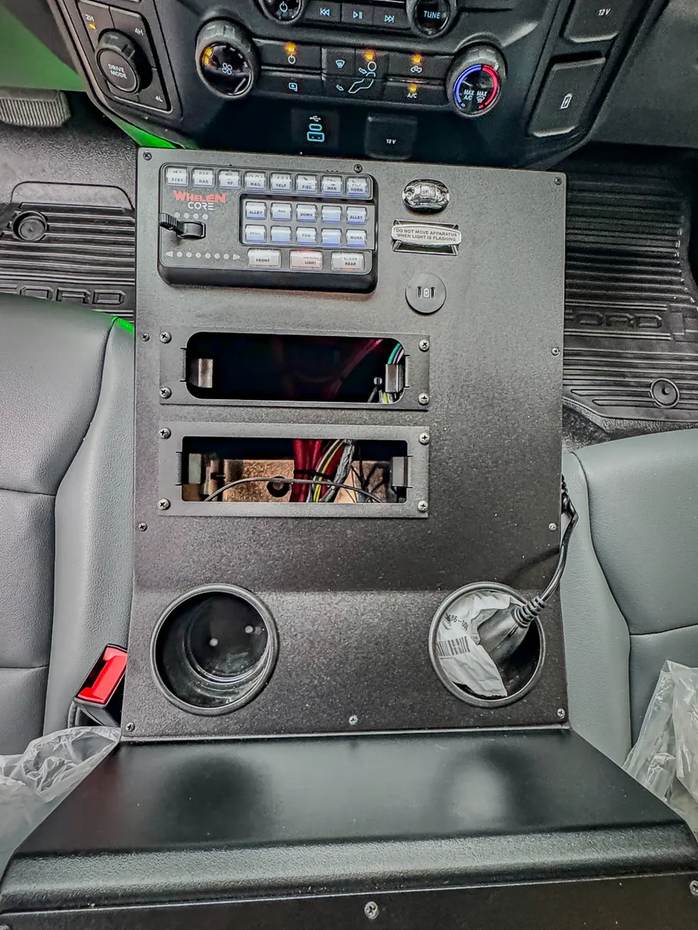 Center console close-up with open storage bays, controls, and cup holders.