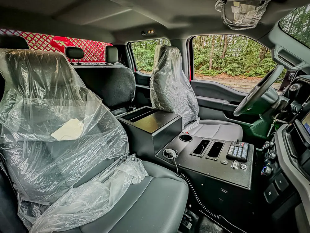 Front seats and center console view with protective plastic covers.