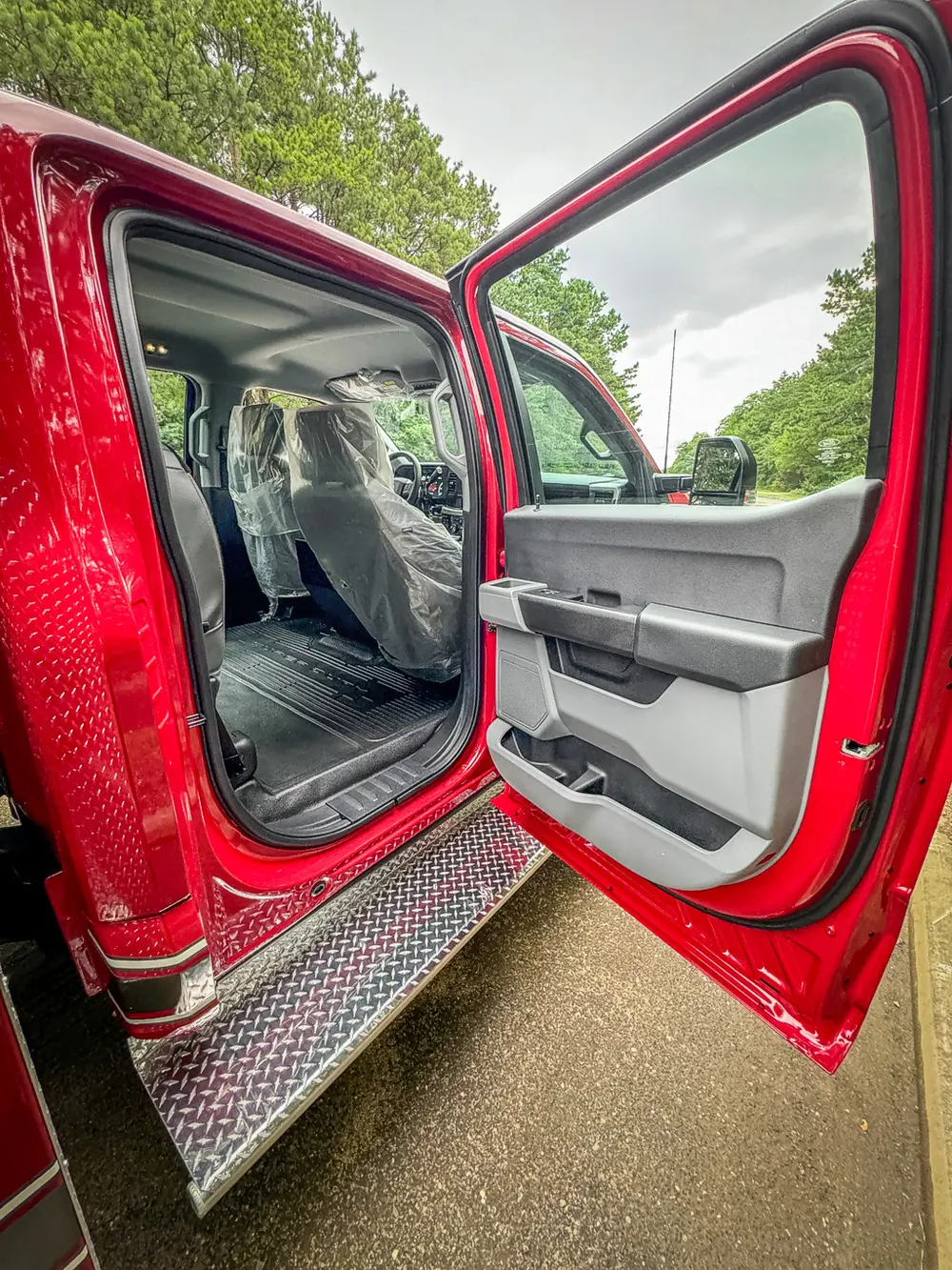 Open rear passenger door view showing rear seat and floor area.