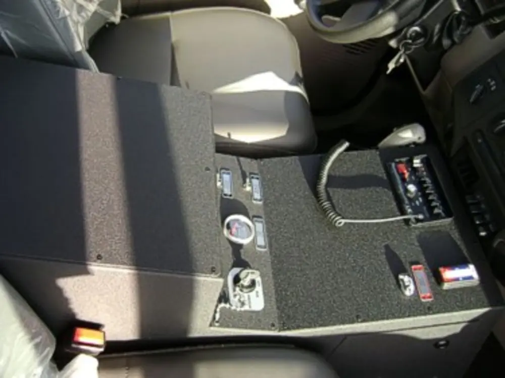 Exterior view of small fire truck showing cab, body compartments, and wheel/tire area.