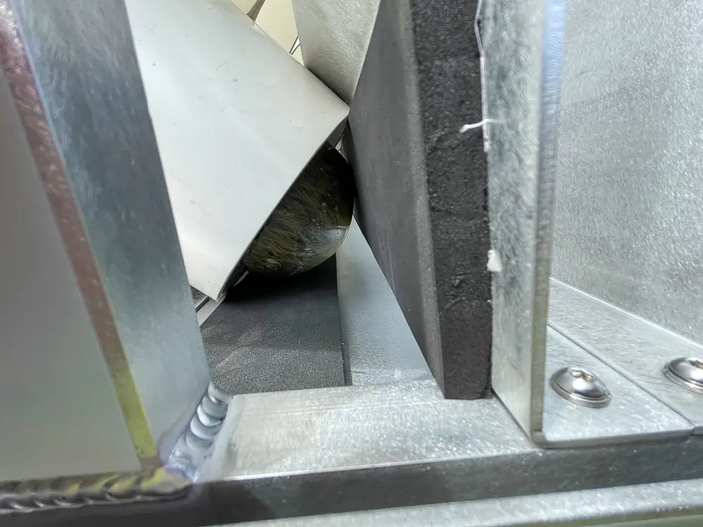 Exterior view of small fire truck showing cab, body compartments, and wheel/tire area.