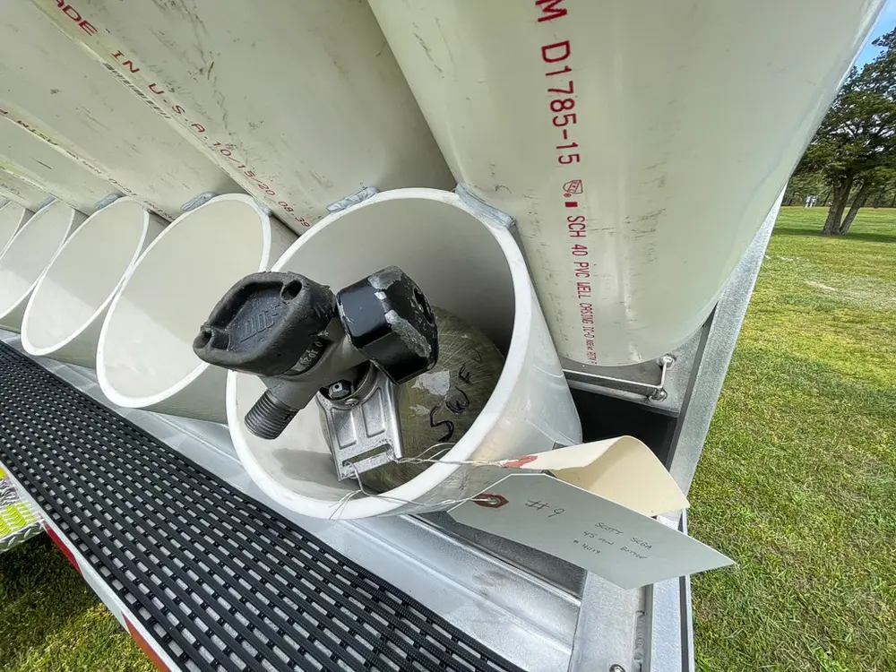 Exterior view of small fire truck showing cab, body compartments, and wheel/tire area.