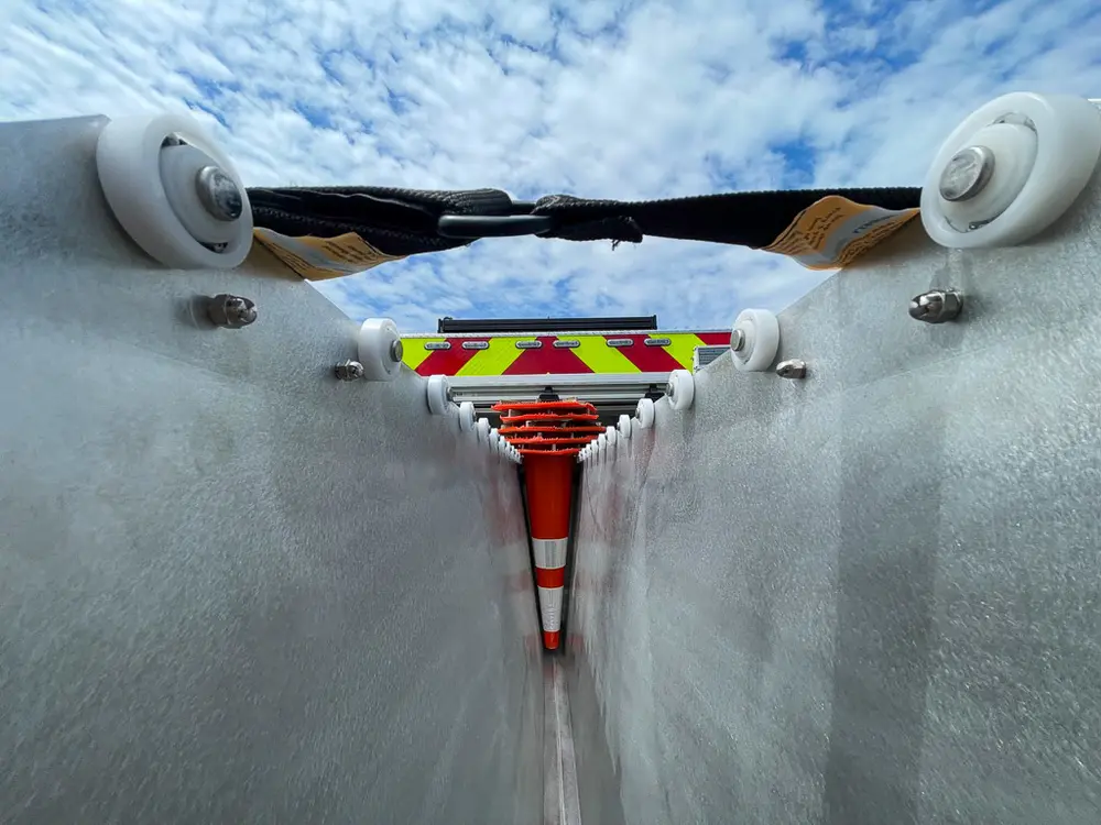 Exterior view of small fire truck showing cab, body compartments, and wheel/tire area.