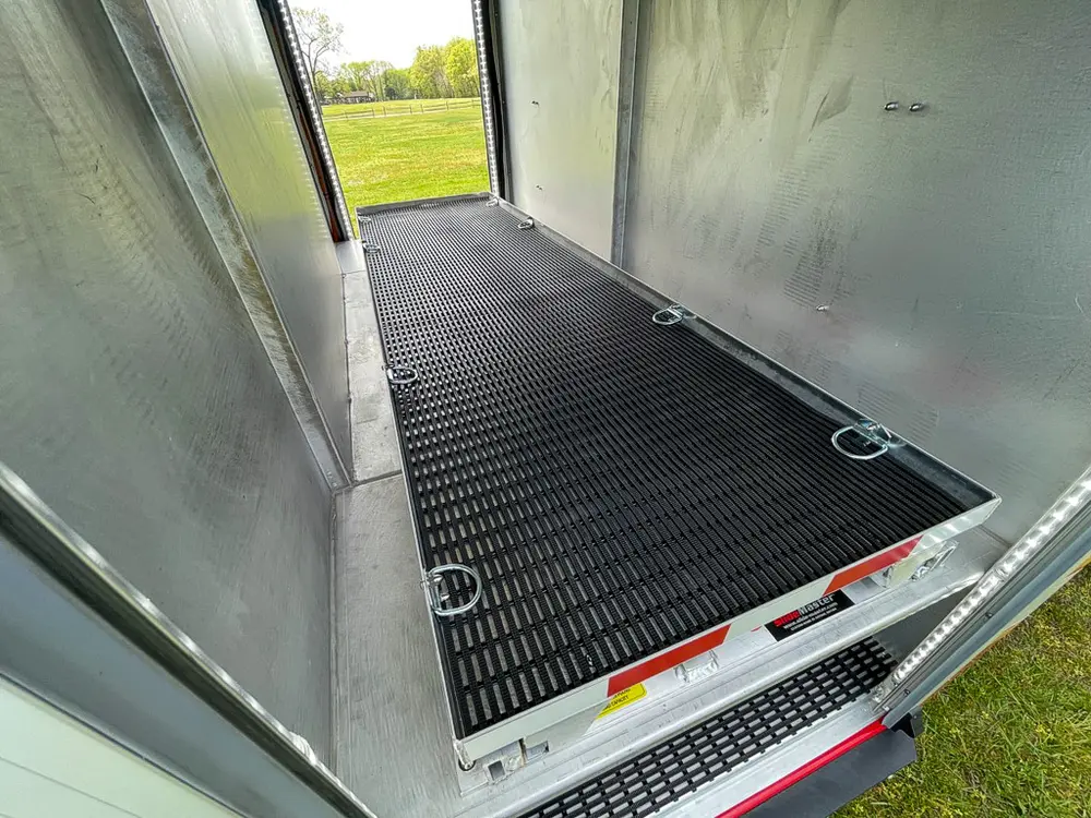 Exterior view of small fire truck showing cab, body compartments, and wheel/tire area.