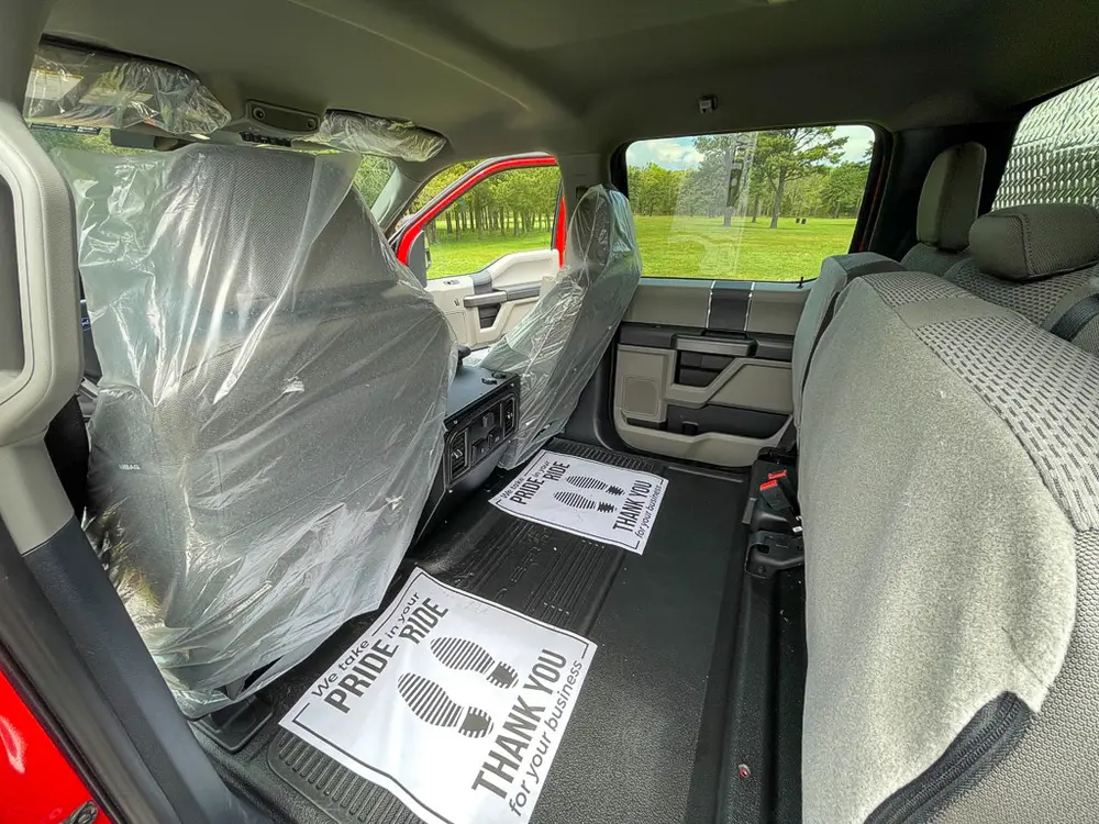 Exterior view of small fire truck showing cab, body compartments, and wheel/tire area.