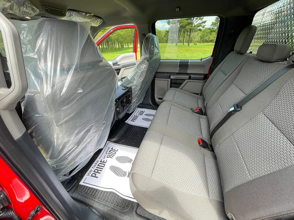 Exterior view of small fire truck showing cab, body compartments, and wheel/tire area.
