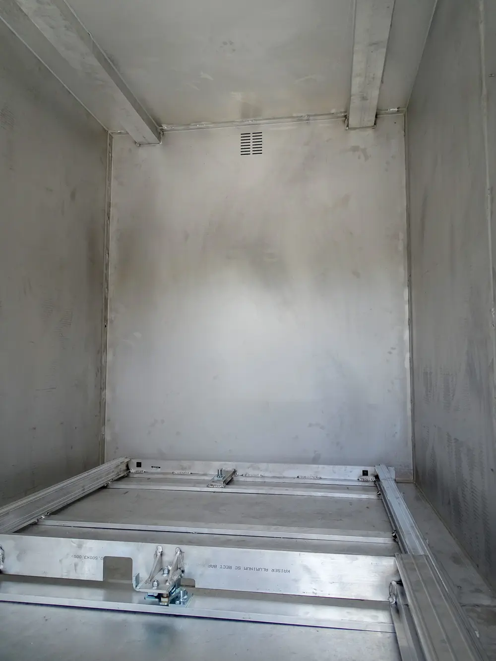 Exterior view of small fire truck showing cab, body compartments, and wheel/tire area.