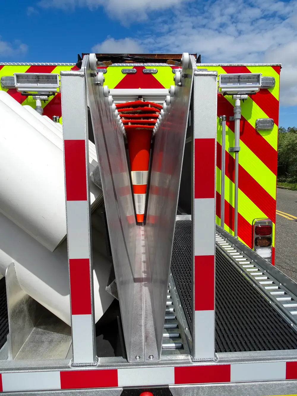 Exterior view of small fire truck showing cab, body compartments, and wheel/tire area.