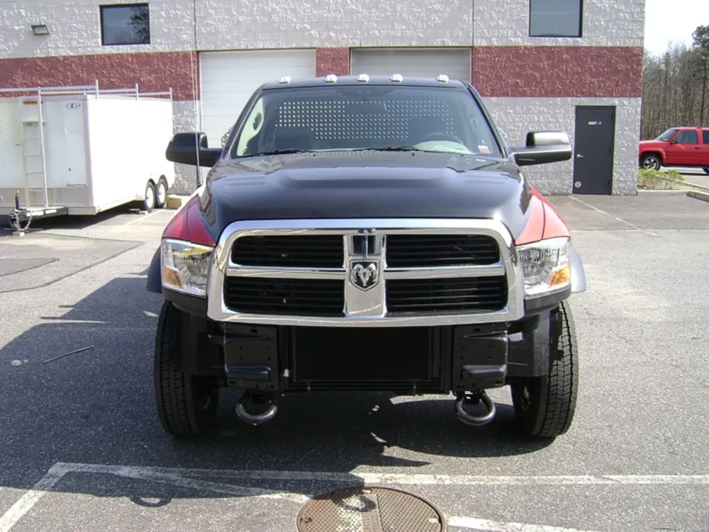 Exterior view of small fire truck showing cab, body compartments, and wheel/tire area.
