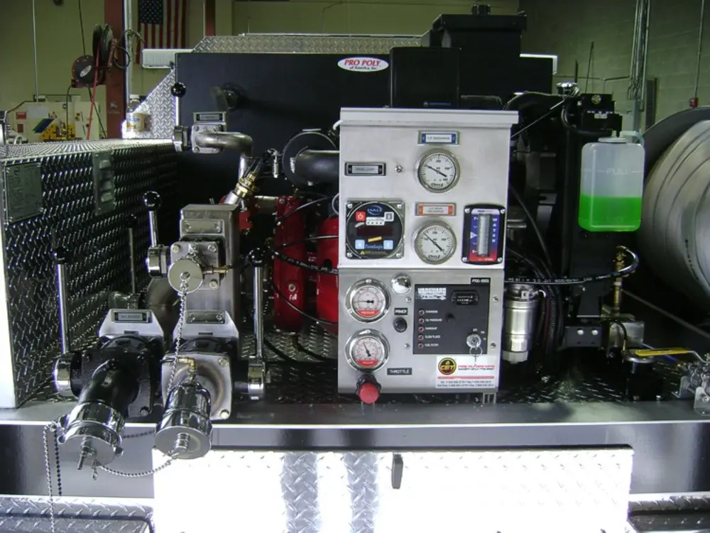 Exterior view of small fire truck showing cab, body compartments, and wheel/tire area.