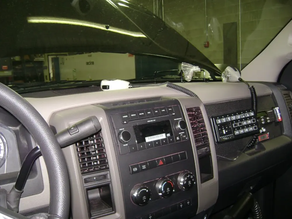 Exterior view of small fire truck showing cab, body compartments, and wheel/tire area.