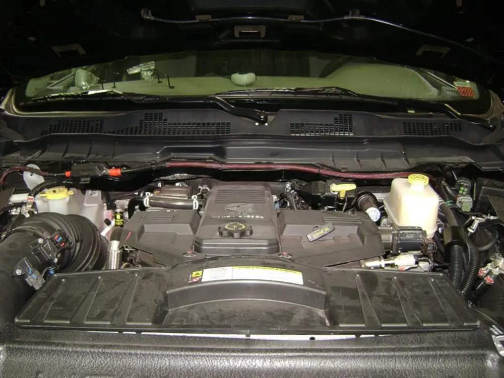 Exterior view of small fire truck showing cab, body compartments, and wheel/tire area.